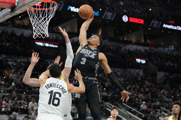 Dec 26, 2023; San Antonio, Texas, USA; San Antonio Spurs forward Keldon Johnson (3) dunks over Utah Jazz forward Simone Fontecchio (16) in the second half at Frost Bank Center.